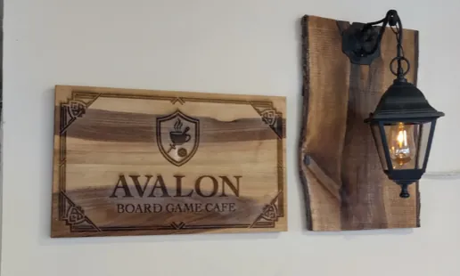 Дървена табела Avalon Board Game Cafe и декоративен дървен панел с фенер във Варна.